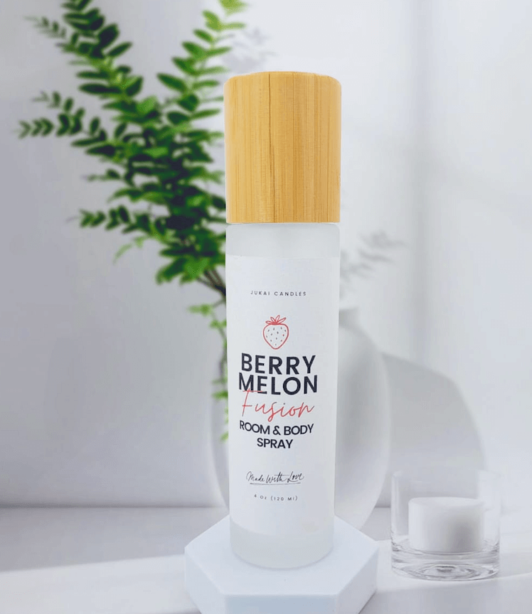 Room and body spray with a wooden cap on a white surface with a plant in the background