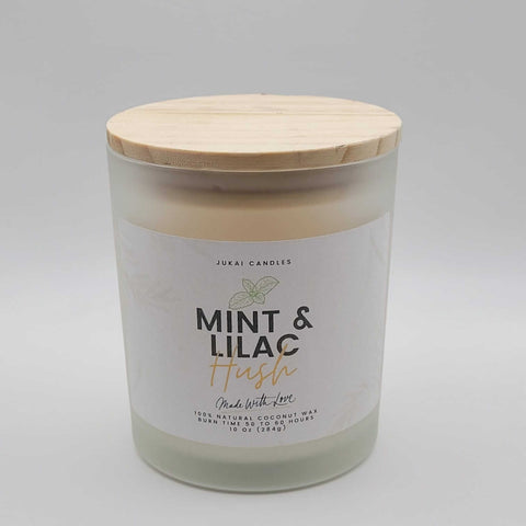 Candle with wooden lid labeled 'Mint & Lilac' on a gray background